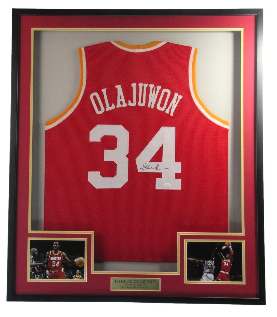 Framed Houston Rockets Jersey Signed by Hakeem Olajuwon with JSA Authentication: Framed Houston Rockets Jersey Signed by Hakeem Olajuwon with JSA Authentication This framed custom Houston Rockets basketball jersey features the authentic hand-signed autograph of Hakeem Olajuwon. Th