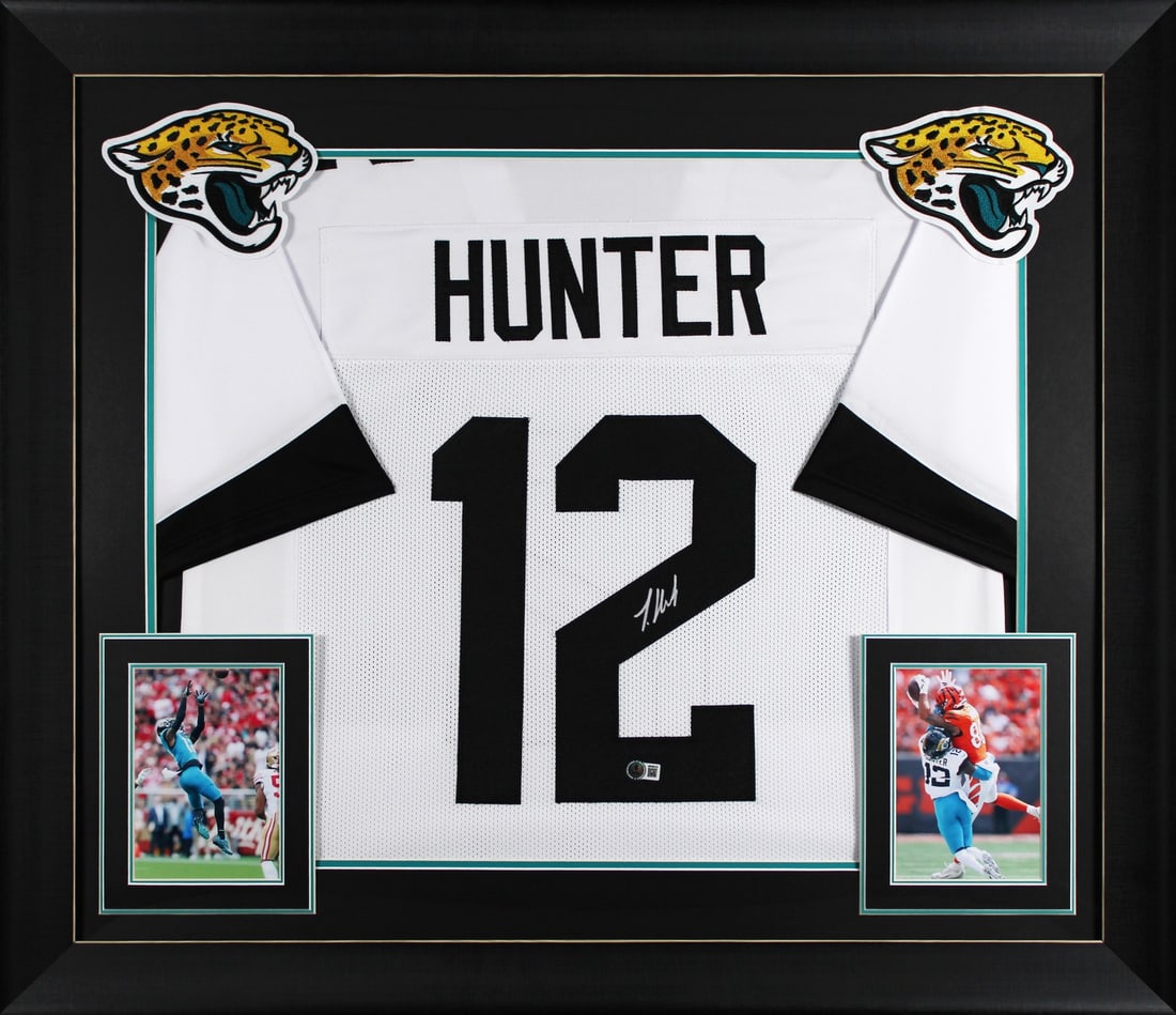 Framed Jacksonville Jaguars Jersey Signed by Travis Hunter BAS Witnessed: Framed Jacksonville Jaguars Jersey Signed by Travis Hunter BAS Witnessed This framed white pro style jersey has been personally signed by Travis Hunter of the Jacksonville Jaguars. It is authenticated