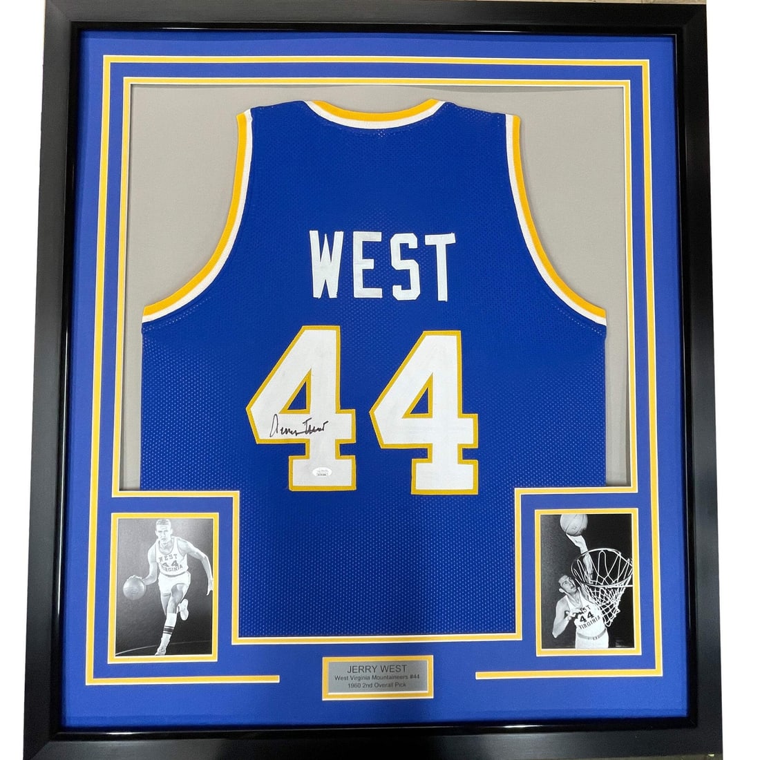 Framed Jerry West Autographed Blue Jersey with JSA COA: Framed Jerry West Autographed Blue Jersey with JSA COA This framed autographed jersey features the iconic Jerry West, a celebrated athlete from the West Virginia Mountaineers. The jersey is presented 