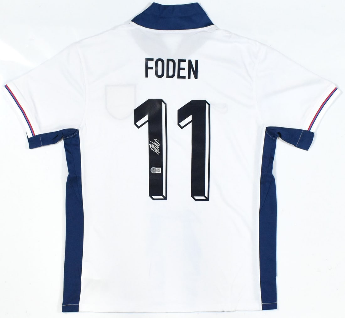 England Home Jersey Signed by Phil Foden with Beckett Hologram: England Home Jersey Signed by Phil Foden with Beckett Hologram This is a pre-owned England home soccer jersey, featuring the number 11 and autographed by Phil Foden. The jersey is authenticated with a