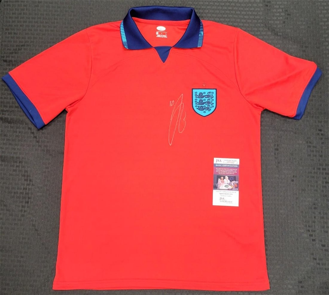 Jude Bellingham England Jersey Signed with JSA COA: Jude Bellingham England Jersey Signed with JSA COA This is an original signed England jersey featuring the autograph of soccer star Jude Bellingham, who currently plays for Real Madrid. The jersey com