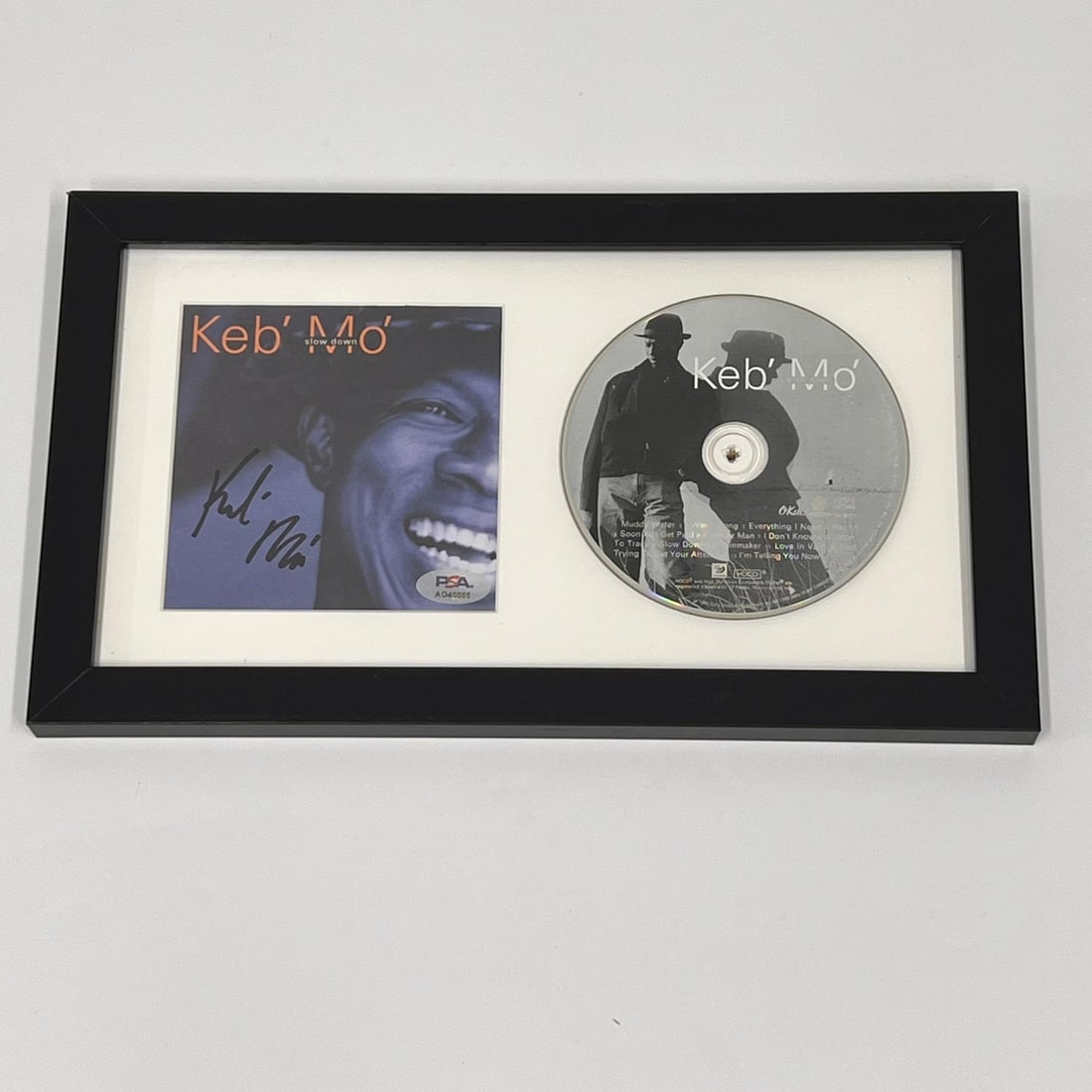 Keb Mo Signed Slow Down CD Cover Framed PSA/DNA Authenticated Music Memorabilia: Keb Mo Signed Slow Down CD Cover Framed PSA/DNA Authenticated Music Memorabilia This listing features a framed CD album of 'Slow Down' by Keb Mo, showcasing his authentic signature on the cover. The a