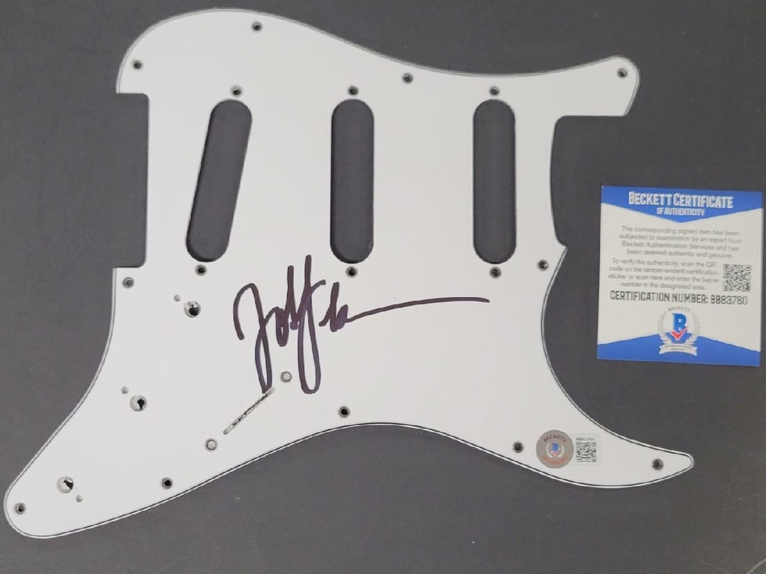 Guitar Pickguard Autographed by John Feldmann Beckett Certified: Guitar Pickguard Autographed by John Feldmann Beckett Certified This is an original guitar pickguard signed by John Feldmann of Goldfinger. The autograph has been authenticated by Beckett and comes wi
