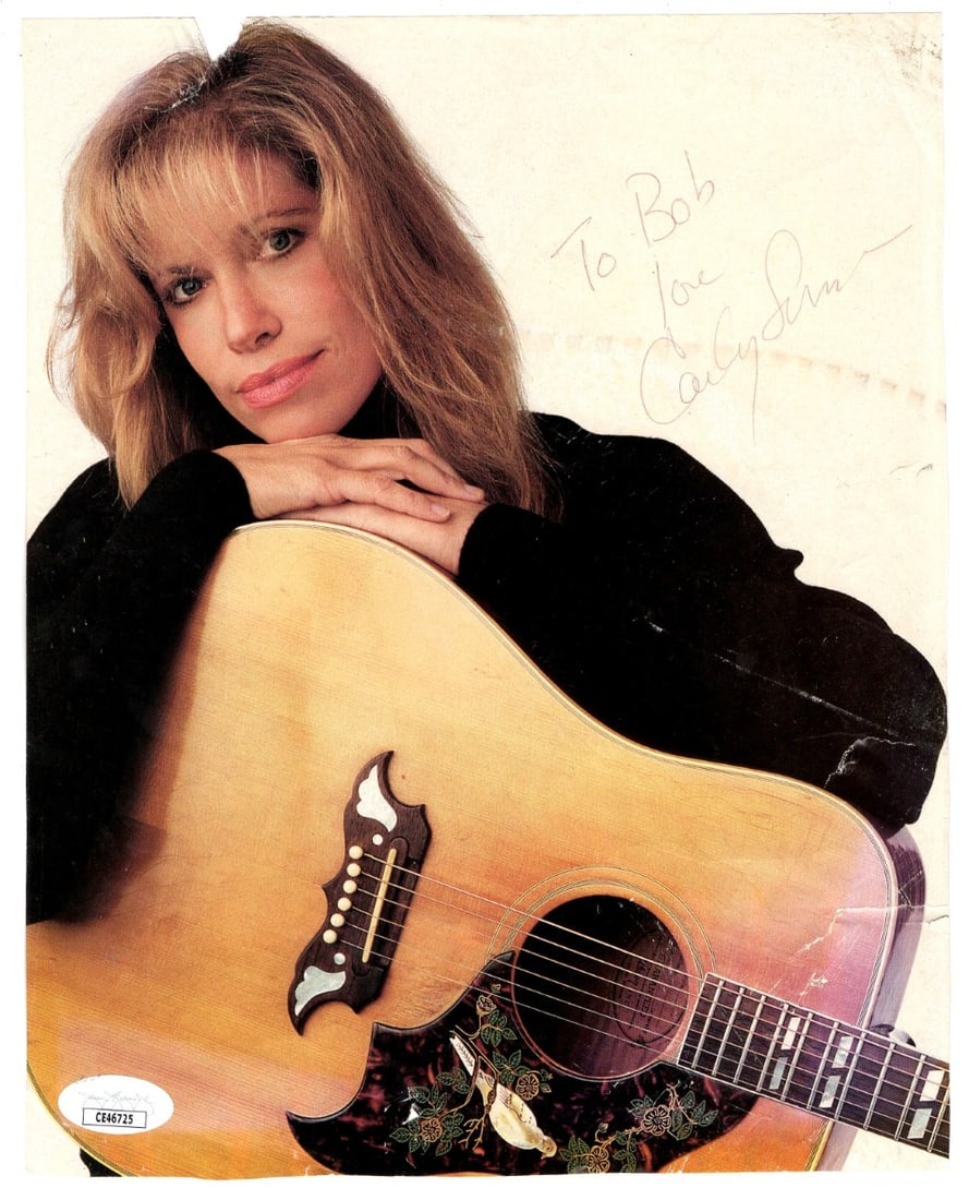 Carly Simon Signed 8x10 Photo Holding Guitar JSA Authenticated: Carly Simon Signed 8x10 Photo Holding Guitar JSA Authenticated This is an original 8 x 10 photograph of Carly Simon, signed by the artist herself. The photo captures a memorable moment of Carly holdin