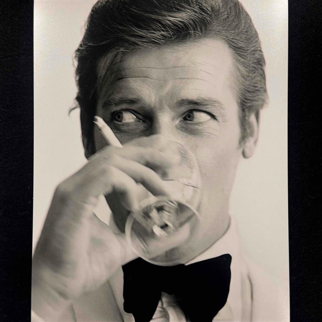 8x10 Reproduction Photo Roger Moore as James Bond with Ouzo For Your Eyes Only: 8x10 Reproduction Photo Roger Moore as James Bond with Ouzo For Your Eyes Only This is a reproduction 8x10 inch movie photograph from the film 'For Your Eyes Only' featuring James Bond, portrayed by S