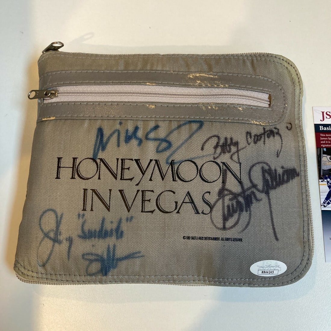 Honeymoon In Vegas Signed Bag Nicolas Cage JSA Authenticated: Honeymoon In Vegas Signed Bag Nicolas Cage JSA Authenticated This is a pre-owned signed bag from the film "Honeymoon In Vegas," featuring the autographs of Nicolas Cage, Burton Gilliam, Johnny William