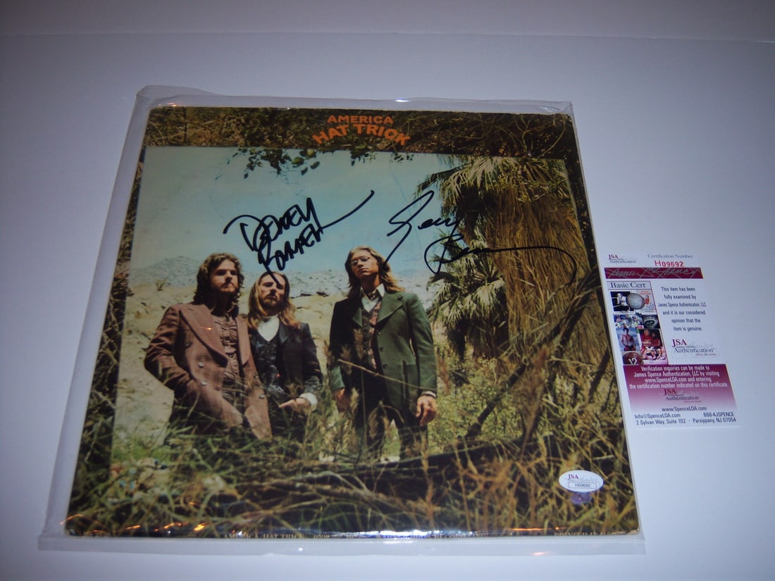 Signed America Hat Trick LP Album with Dual Autographs JSA COA: Signed America Hat Trick LP Album with Dual Autographs JSA COA This is an original "Hat Trick" LP record album by America, featuring two signatures. The album comes from the United States and is in pr