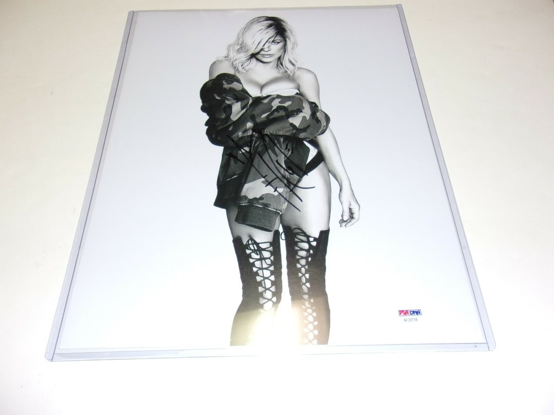 Fergie Autographed 11x14 Photograph with White Orchid PSA/DNA Authenticated: Fergie Autographed 11x14 Photograph with White Orchid PSA/DNA Authenticated This is an original 11x14 photograph featuring Fergie, the singer from the Black Eyed Peas, in her White Orchid model. The p