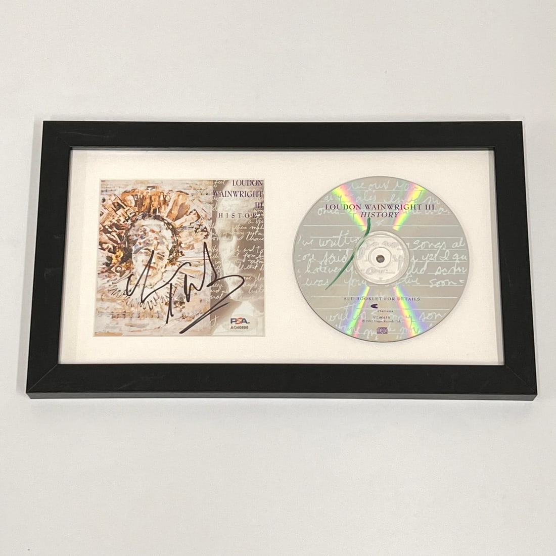 Loudon Wainwright III Signed History Album CD Cover Framed PSA/DNA Authenticated: Loudon Wainwright III Signed History Album CD Cover Framed PSA/DNA Authenticated This framed CD album cover features the signature of renowned artist Loudon Wainwright III. The autograph has been auth