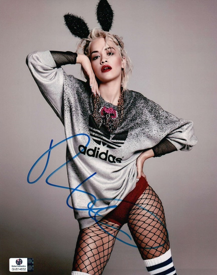 Rita Ora Autographed 8x10 Photo with Bunny Ears and Fishnets: Rita Ora Autographed 8x10 Photo with Bunny Ears and Fishnets Capture a piece of pop culture with this Rita Ora signed 8X10 photograph. Featuring the artist in playful bunny ears and sexy fishnets, thi