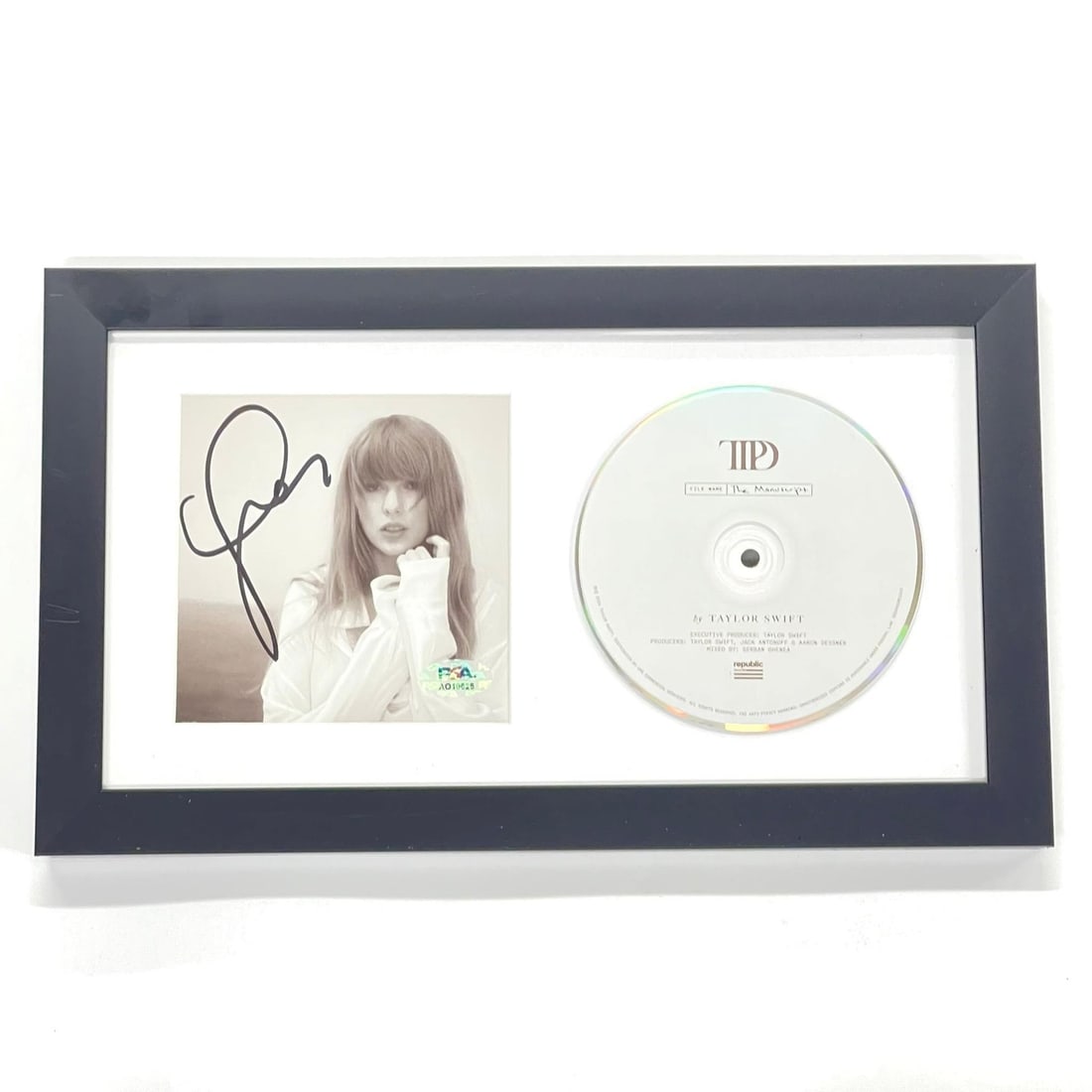 Framed Taylor Swift Autographed The Tortured Poets Department Album Cover PSA/DNA: Framed Taylor Swift Autographed The Tortured Poets Department Album Cover PSA/DNA This is a framed CD album cover for "The Tortured Poets Department" signed by Taylor Swift. The autograph has been aut