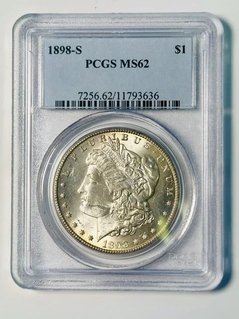 1898-S Morgan dollar PCGS MS-62 silver coin: 1898-S Morgan dollar PCGS MS-62 silver coin This 1898 Morgan Silver Dollar was minted in San Francisco and has been certified by PCGS with a grade of MS 62. Composed of silver, this pre-owned coin rep