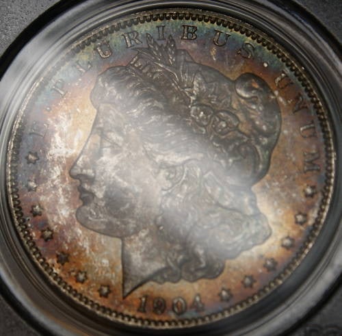 PCGS MS-63 1904-O Morgan Dollar Uncirculated Silver Coin with Toning: PCGS MS-63 1904-O Morgan Dollar Uncirculated Silver Coin with Toning This is a 1904-O Morgan Silver Dollar coin from the United States, minted in New Orleans. The coin is certified by PCGS with a grad