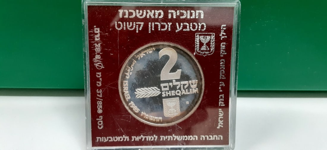 1985 Silver 2 Sheqalim Hanukkiya Ashkenaz Commemorative Coin With Case: 1985 Silver 2 Sheqalim Hanukkiya Ashkenaz Commemorative Coin With Case This 1985 Israel 2 Sheqalim silver proof coin commemorates the Hanukkiya from Ashkenaz. The coin is composed of silver and has a 