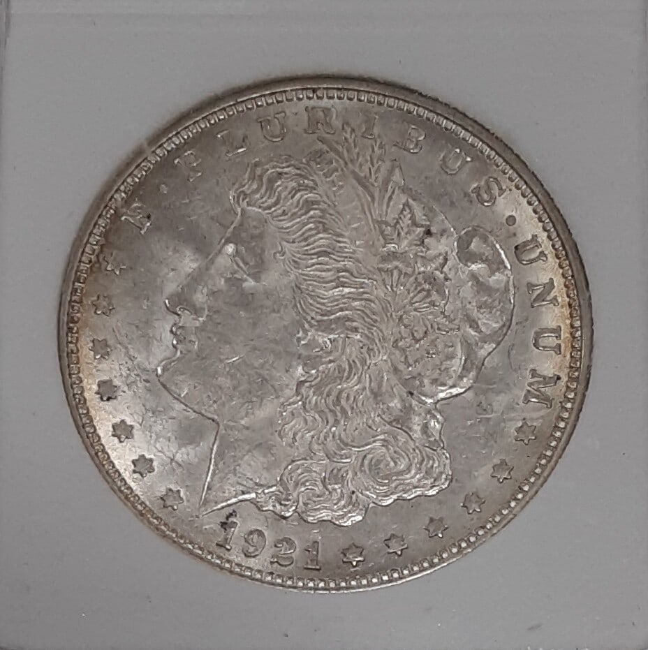 1921-D Morgan Silver Dollar from Denver in Hard Plastic Holder with Light Toning: 1921-D Morgan Silver Dollar from Denver in Hard Plastic Holder with Light Toning This is a 1921-D Morgan Silver Dollar $1 coin from the United States, minted in Denver. The coin is composed of silver,