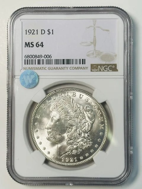 NGC MS-64 1921 Denver Morgan Silver Dollar: NGC MS-64 1921 Denver Morgan Silver Dollar This 1921 Morgan Silver Dollar was minted in Denver and has been graded MS-64 by NGC. Composed of silver, this pre-owned coin features the classic Morgan Dol