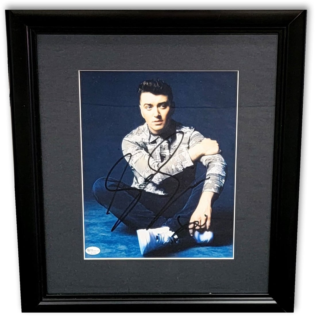 Sam Smith Autographed 8x10 Photo Framed Online Authentics: Sam Smith Autographed 8x10 Photo Framed Online Authentics This is an authentic, framed 8x10 photo of Sam Smith, featuring the artist sitting with their legs crossed. The frame measures approximately 1