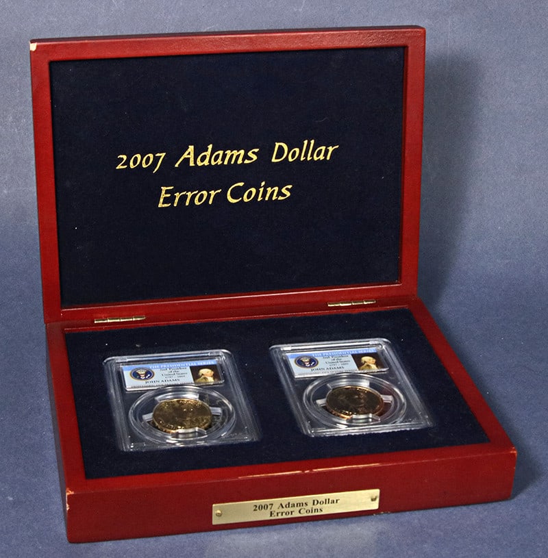 Set of 2 2007-P John Adams Dollar Error Coins PCGS MS64 With Display Box: Set of 2 2007-P John Adams Dollar Error Coins PCGS MS64 With Display Box This 2007-P John Adams Presidential Dollar 2-piece error set features one coin with inverted doubled edge lettering and one coi