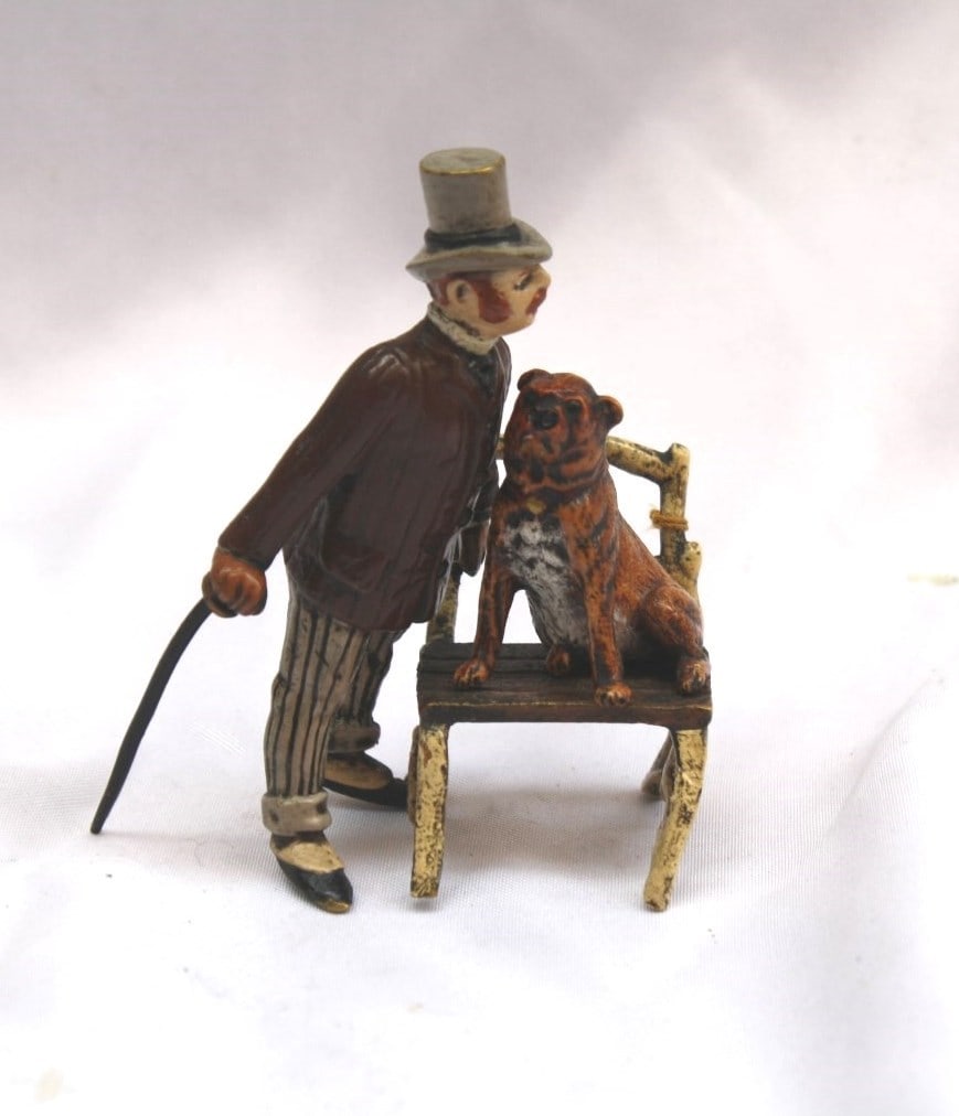 1900 Austrian Bronze Sculpture Man Training Dog: 1900 Austrian Bronze Sculpture Man Training Dog This exquisite 1900's Austrian bronze sculpture depicts a man training his dog while seated on a chair. The piece showcases remarkable subject matter, i