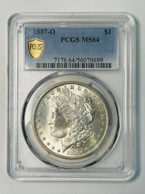 1887 New Orleans Morgan Silver Dollar PCGS MS64: 1887 New Orleans Morgan Silver Dollar PCGS MS64 This 1887 Morgan Silver Dollar was minted in New Orleans and has been graded MS-64 by PCGS. Composed of silver, this pre-owned coin is a certified examp