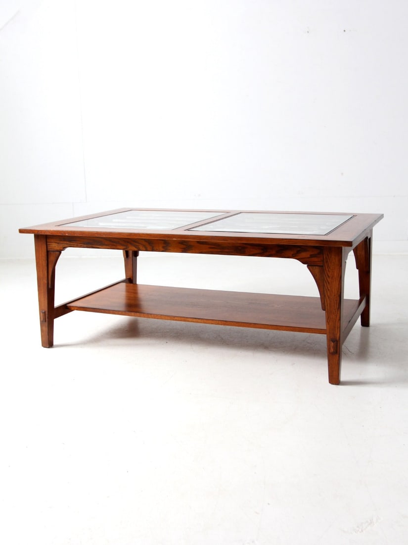 Vintage Wooden Coffee Table with Glass Top and Lower Shelf: Vintage Wooden Coffee Table with Glass Top and Lower Shelf This vintage coffee table seamlessly combines style and functionality, featuring a glass-paneled top elegantly set within a warm-toned wooden