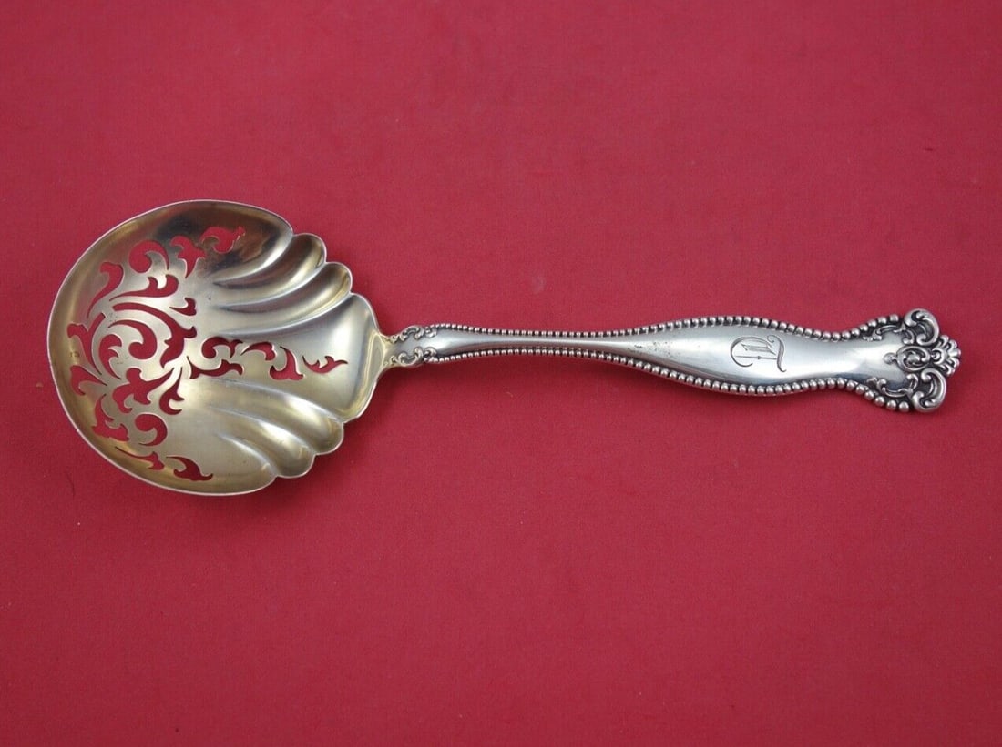 Alvin Raleigh Sterling Silver Pea Spoon Gold Washed 8 3/8": Alvin Raleigh Sterling Silver Pea Spoon Gold Washed 8 3/8" This elegant serving spoon is a stunning example of the Raleigh pattern by Alvin, crafted from high-quality sterling silver. Measuring 8 3/8 
