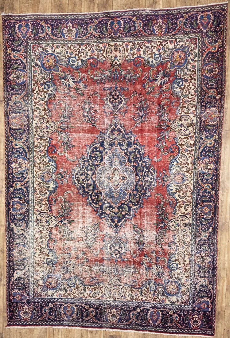 Hand Knotted Wool Floral Oriental Area Rug 7'1 x 10'6: Hand Knotted Wool Floral Oriental Area Rug 7'1 x 10'6 This semi-antique hand-knotted Oriental rug features a distressed floral pattern in muted tones of red, purple-navy, cream, brown, blue, and green