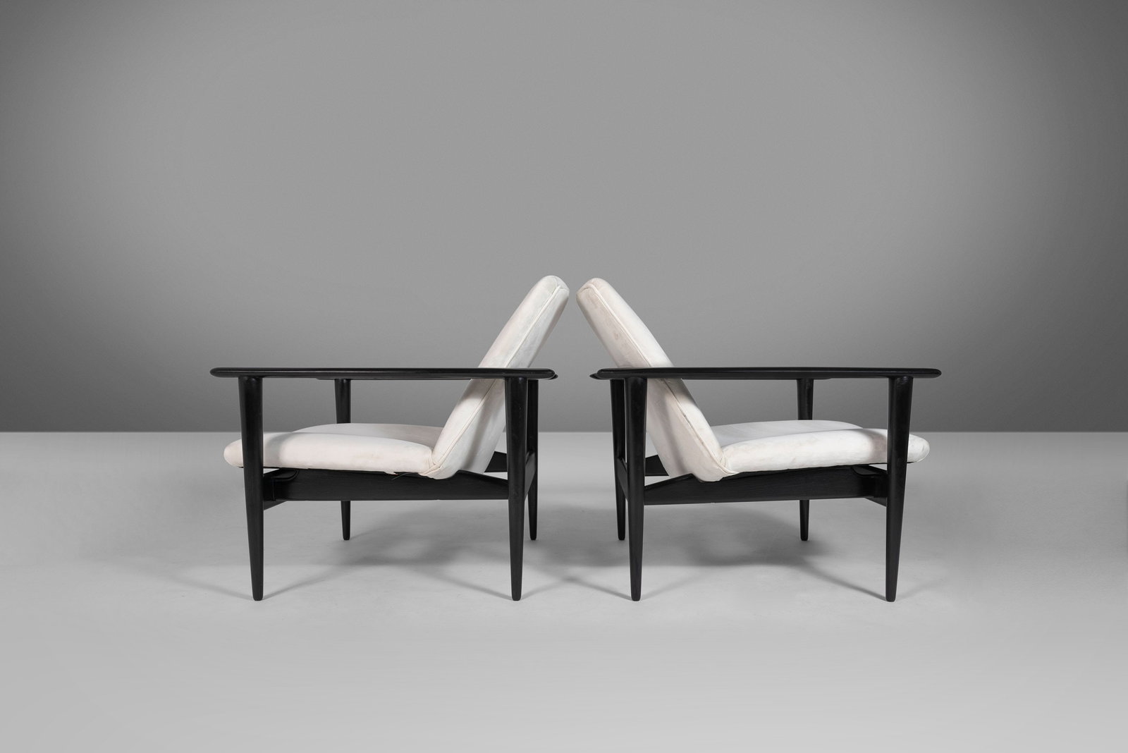 Set of 2 Ebonized Danish Modern Lounge Chairs by Hans Wegner Newly Upholstered: Set of 2 Ebonized Danish Modern Lounge Chairs by Hans Wegner Newly Upholstered This set of two ebonized Danish Modern lounge chairs, attributed to Hans Wegner, showcases exceptional architectural desi
