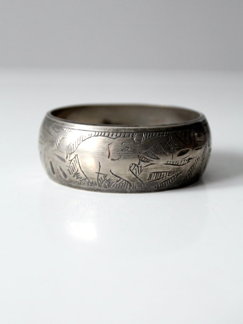 Vintage Silver Tone Elephant Etched Bangle Bracelet: Vintage Silver Tone Elephant Etched Bangle Bracelet Discover this charming vintage etched bangle bracelet featuring a wide, chunky design. Crafted in a silver tone, it showcases an intricate etched de