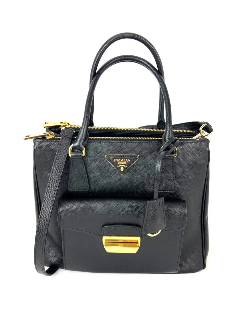 Prada Saffiano Black Leather Tote with Double Zip and Front Pocket: Prada Saffiano Black Leather Tote with Double Zip and Front Pocket This Prada Safriano Front Pocket Double Zip tote bag features a trapezoid silhouette crafted from black coated leather with gold-plat