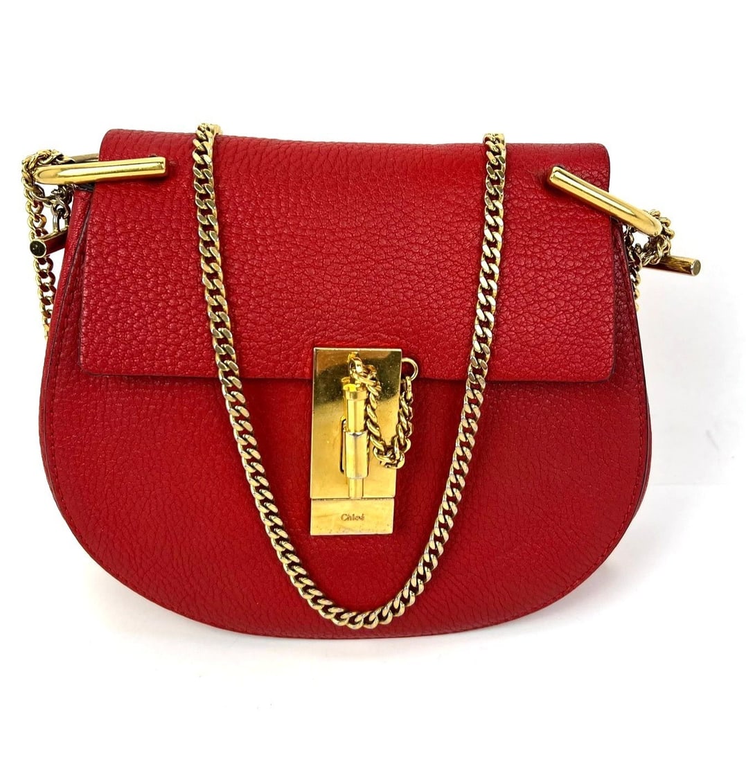 Chloe Drew Mini Red Pebbled Leather Crossbody Bag: Chloe Drew Mini Red Pebbled Leather Crossbody Bag This Chloe Mini Drew crossbody bag features a crescent shape crafted from grained lambskin leather in a vibrant red color. The bag is accented with go