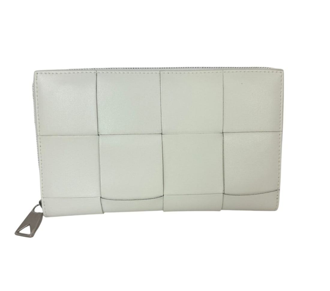 White Leather Cassette Zip Wallet by Bottega Veneta Intrecciato: White Leather Cassette Zip Wallet by Bottega Veneta Intrecciato This Bottega Veneta Cassette wallet features the signature intrecciato woven leather design in white. It is a medium-sized zip-around wa
