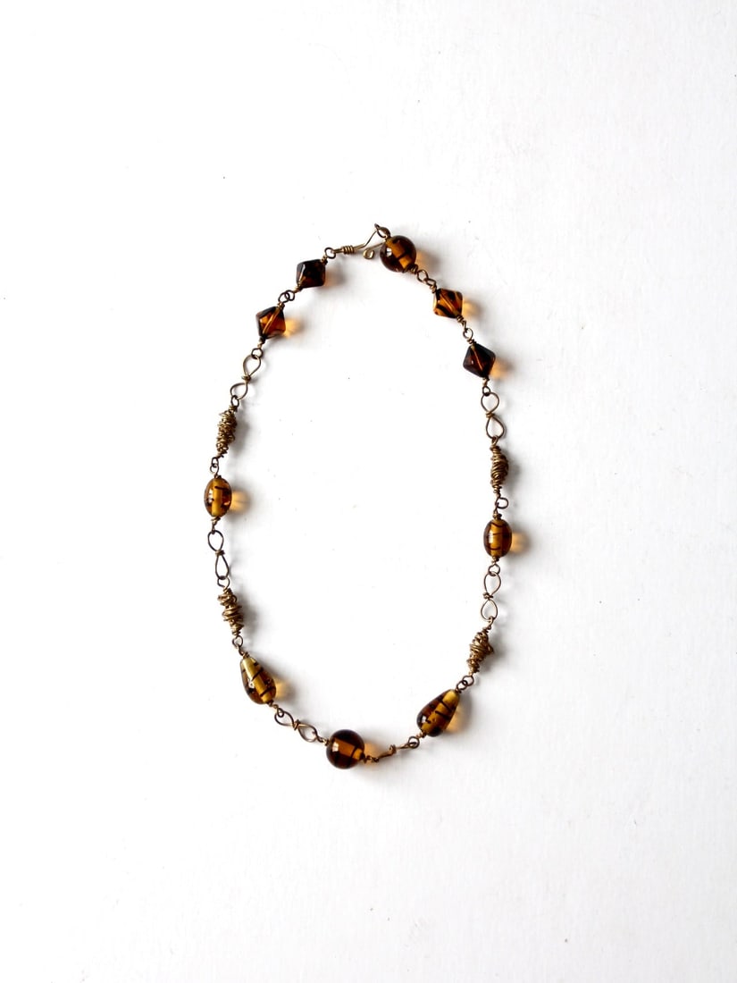 Chic Vintage Amber Beaded Necklace Gold Tone Wire 17.5 Inch: Chic Vintage Amber Beaded Necklace Gold Tone Wire 17.5 Inch This vintage beaded necklace features beautifully wrapped amber beads on a gold tone wire, creating a chic and timeless piece. It includes a