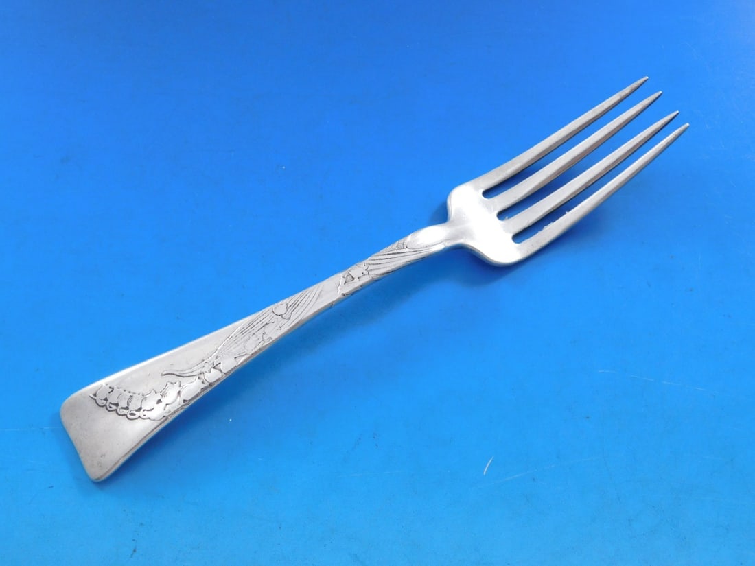 Tiffany & Co Sterling Silver Fork Lap Over Edge Lily of the Valley 7 1/4": Tiffany & Co Sterling Silver Fork Lap Over Edge Lily of the Valley 7 1/4" This exquisite sterling silver fork is a stunning example of Tiffany & Co.'s craftsmanship, featuring the elegant Lap Over Edg