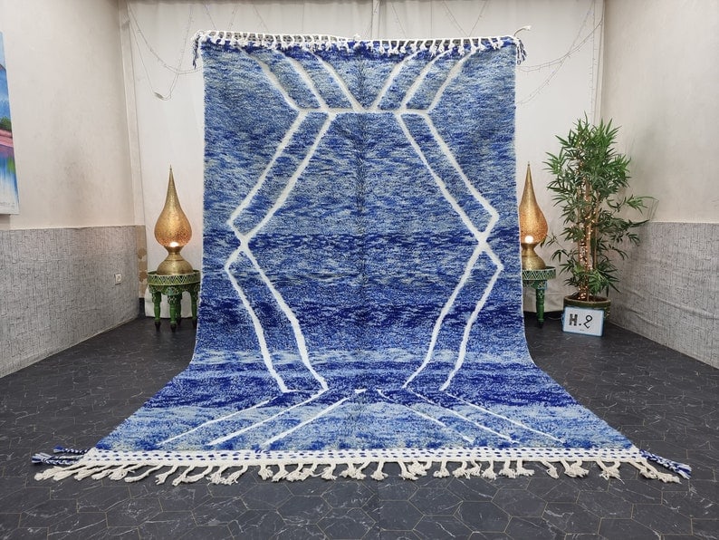 Handmade Moroccan Berber Blue Wool Area Rug 8 x 5 ft: Handmade Moroccan Berber Blue Wool Area Rug 8 x 5 ft Enhance your living space with this luxurious and authentic handmade Moroccan Berber area rug. Featuring a soft blue color and a striking white geo