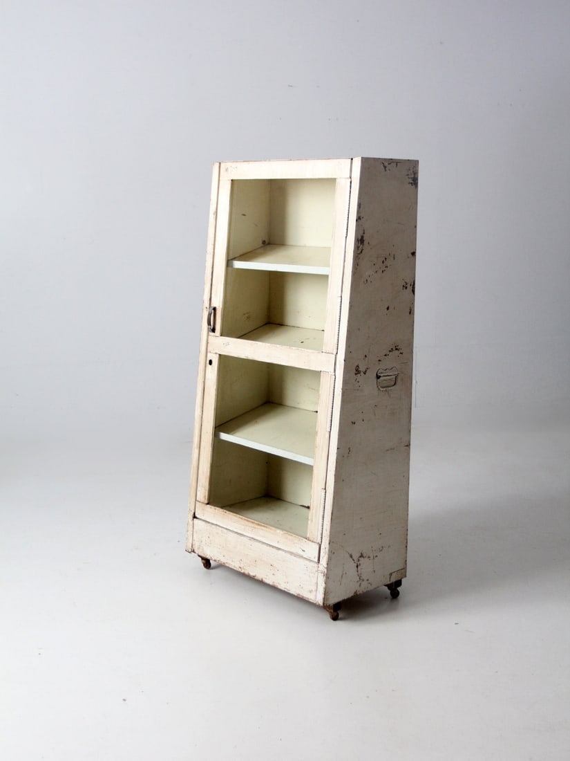 Vintage 20th Century Medical Cabinet with Glass Door and Casters: Vintage 20th Century Medical Cabinet with Glass Door and Casters Discover a charming vintage medical cabinet from the early to mid-20th century, perfect for displaying your favorite items. This off-wh