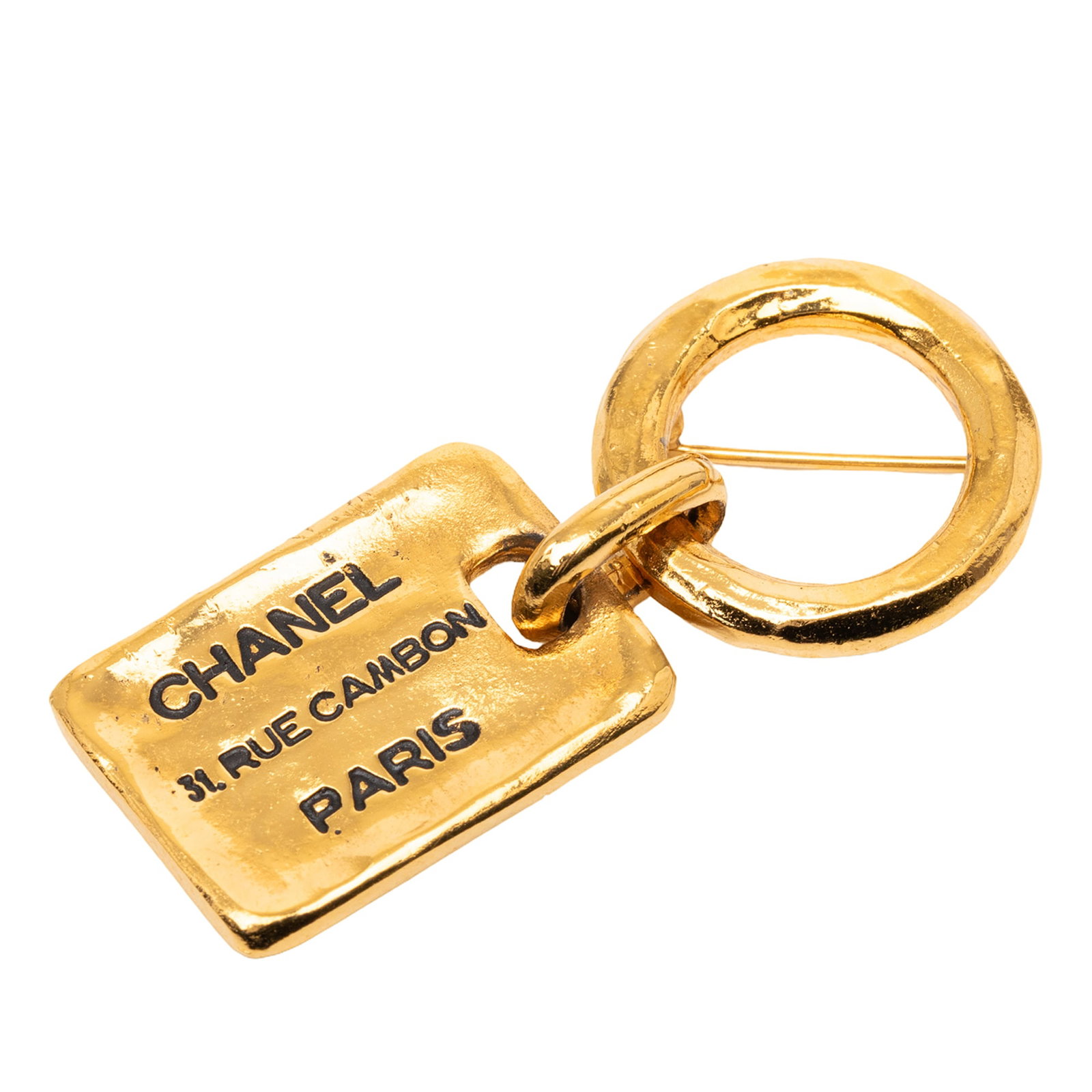 Chanel Rue Cambon Tag Gold Plated Brooch: Chanel Rue Cambon Tag Gold Plated Brooch This Chanel brooch showcases a gold plated metal body with a back pin closure, designed in the recognizable Rue Cambon tag style. The brooch is categorized as 