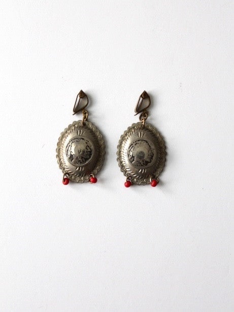 Vintage Southwest Indian Head Coin Drop Earrings with Red Beads: Vintage Southwest Indian Head Coin Drop Earrings with Red Beads Discover a beautiful pair of vintage Southwest Indian Head coin drop earrings, showcasing a unique blend of history and style. These ear