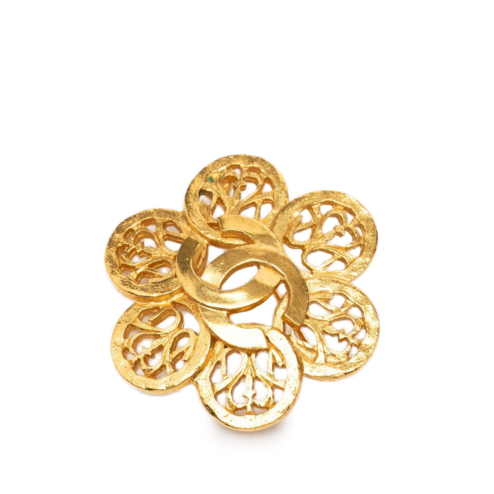 Chanel CC Floral Brooch in Gold Tone Metal: Chanel CC Floral Brooch in Gold Tone Metal This Chanel brooch features a gold tone metal body designed in a floral motif, complete with a back pin closure. It is categorized as costume jewelry and ori