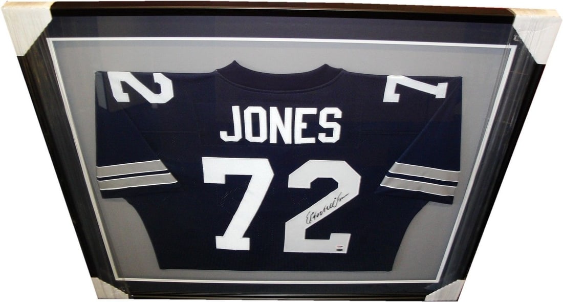 Ed Too Tall Jones PSA DNA Authenticated Signed Cowboys Jersey in Custom Frame: Ed Too Tall Jones PSA DNA Authenticated Signed Cowboys Jersey in Custom Frame This custom framed Dallas Cowboys jersey features the authentic hand signature of Ed "Too Tall" Jones. The jersey is prese