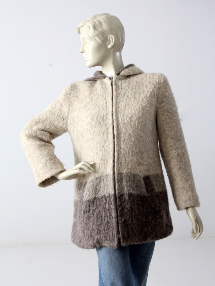 Vintage Hand-Knit Gray Striped Hooded Sweater Coat: Vintage Hand-Knit Gray Striped Hooded Sweater Coat This vintage hand-knit sweater coat is a stylish addition to your wardrobe. Crafted from a cozy wooly gray striped knit, it features practical waist 