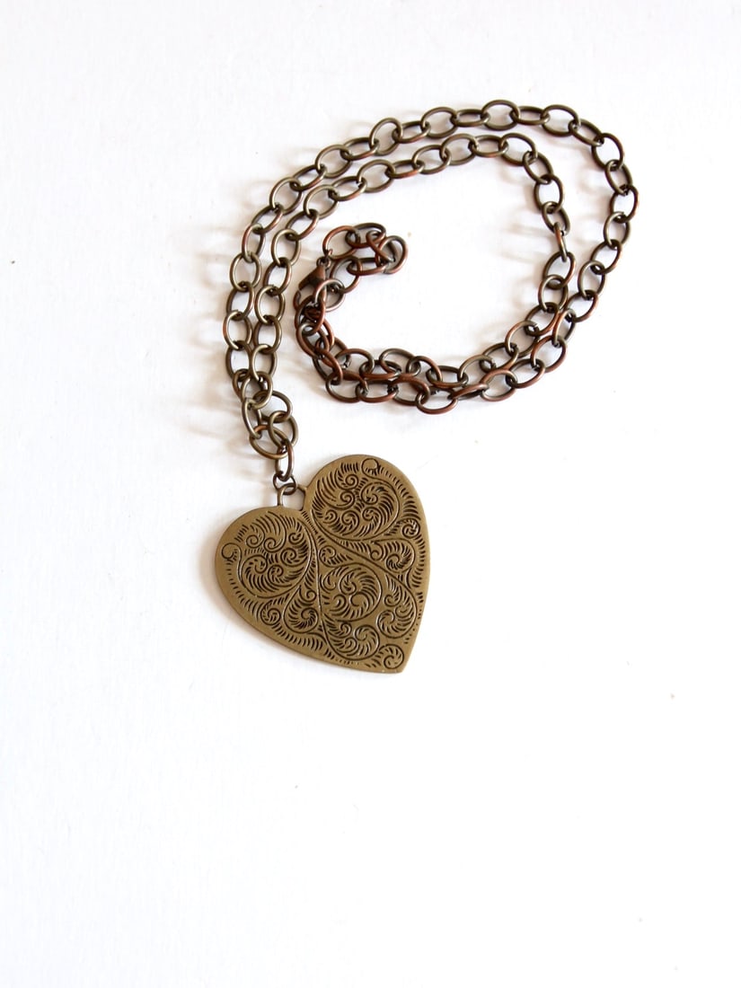 Bold Vintage Heart Pendant Necklace on Brass Tone Chain: Bold Vintage Heart Pendant Necklace on Brass Tone Chain Make a bold statement with this Vintage Heart Pendant Necklace. This striking piece features a large heart-shaped pendant adorned with a swirlin