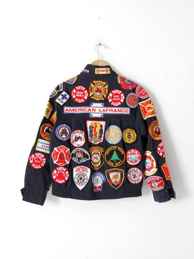 1970s Vintage Sears Firefighter Patch Jacket Unisex: 1970s Vintage Sears Firefighter Patch Jacket Unisex Embrace a piece of history with this vintage 1970s Sears Perma-Press jacket, adorned with a vibrant array of embroidered fire department patches. Ea