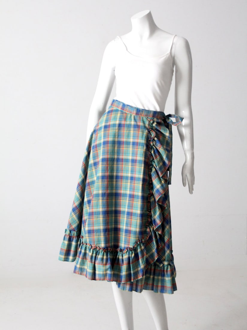 1970s Cotton Plaid Boho Wrap Skirt with Ruffle Hem: 1970s Cotton Plaid Boho Wrap Skirt with Ruffle Hem This 1970s vintage wrap skirt is crafted from lightweight cotton and showcases a vibrant summer plaid pattern in soft blues, greens, yellows, and red