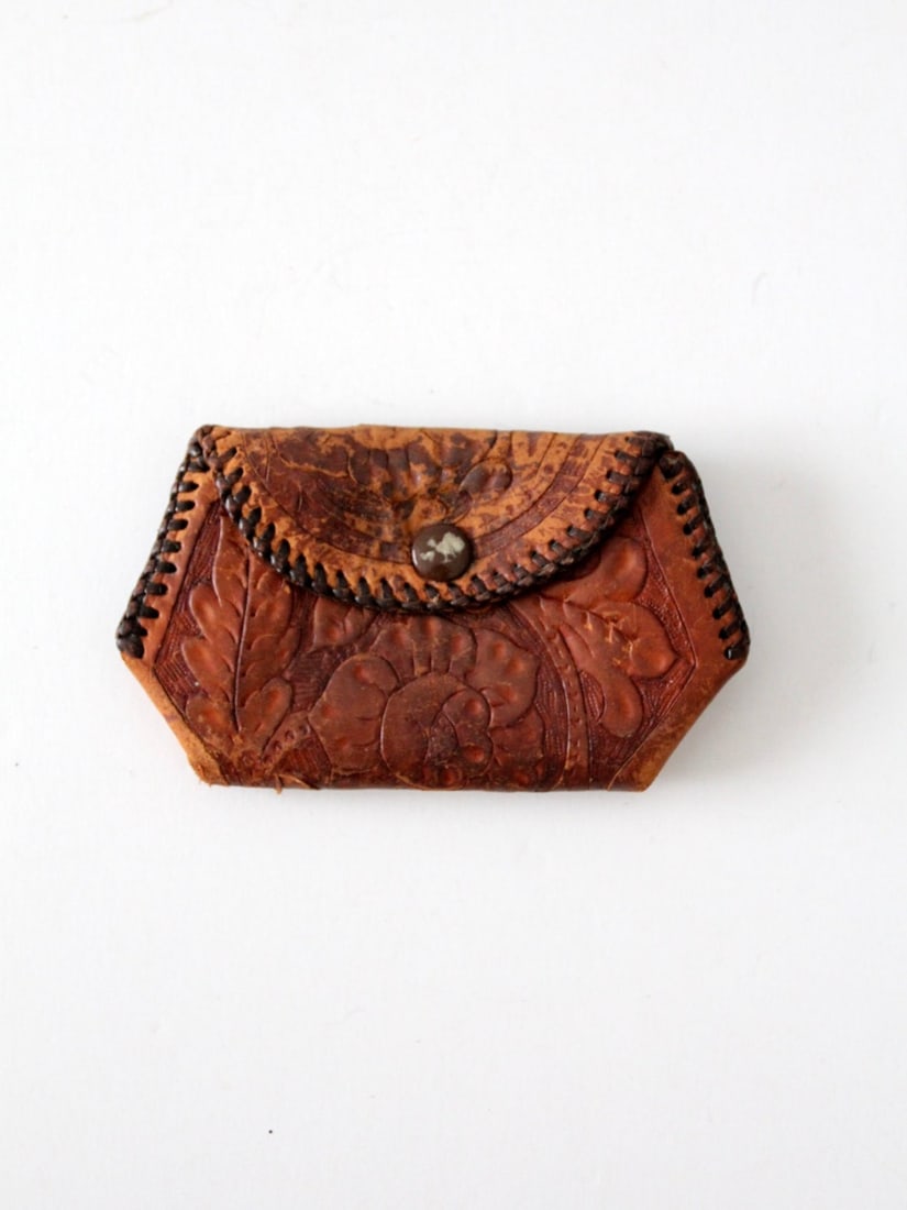 Vintage Tooled Leather Coin Purse with Floral Design: Vintage Tooled Leather Coin Purse with Floral Design This vintage tooled leather coin purse showcases a stunning floral design that is beautifully accentuated by its rich patina. Crafted with whipstit