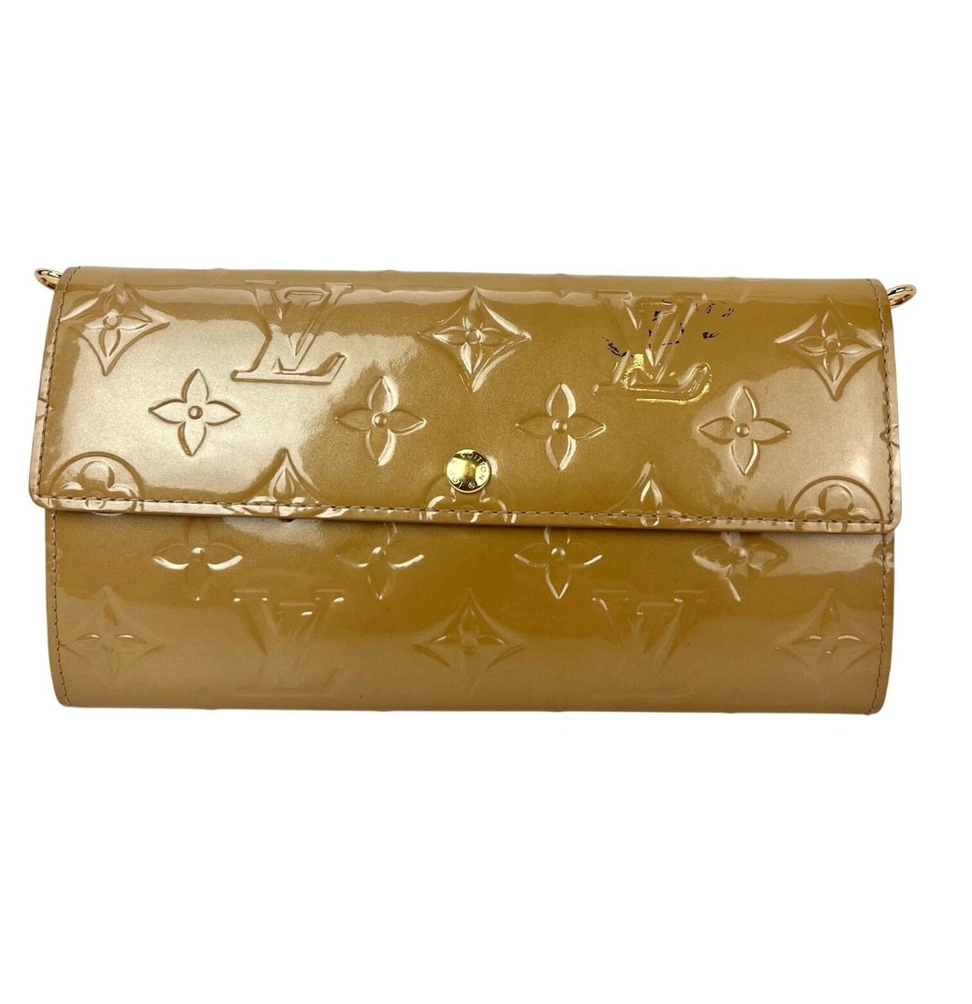 Louis Vuitton Sarah wallet in patent leather for women: Louis Vuitton Sarah wallet in patent leather for women Louis Vuitton Sarah Vernis wallet in beige poudre. This pre-owned women's wallet is crafted from patent leather and features a logo-themed design