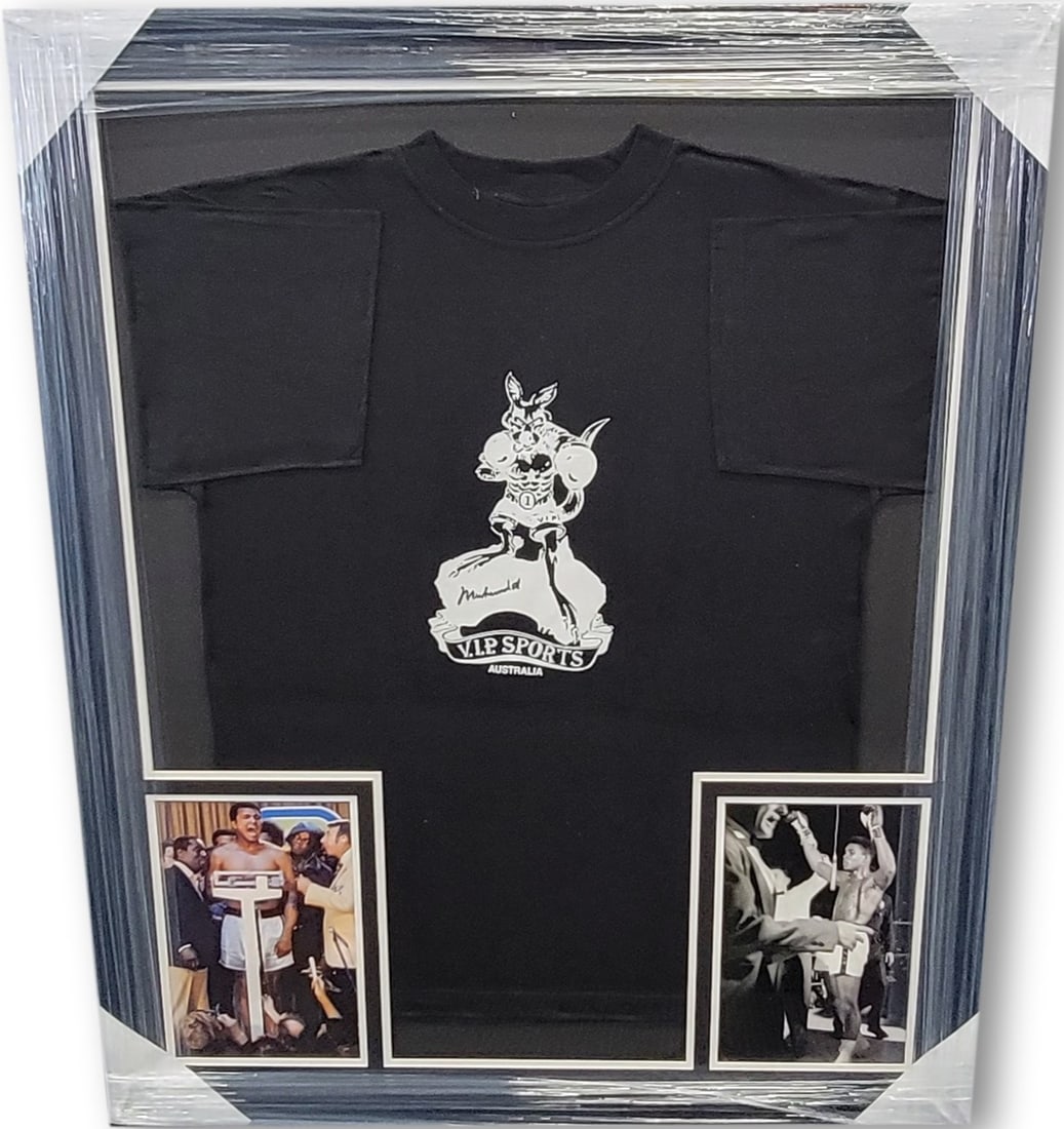 Muhammad Ali Signed Framed T-Shirt with JSA Authentication: Muhammad Ali Signed Framed T-Shirt with JSA Authentication This striking display features a Muhammad Ali signed autograph on a custom-framed T-shirt, accompanied by two unsigned photos of the legendar