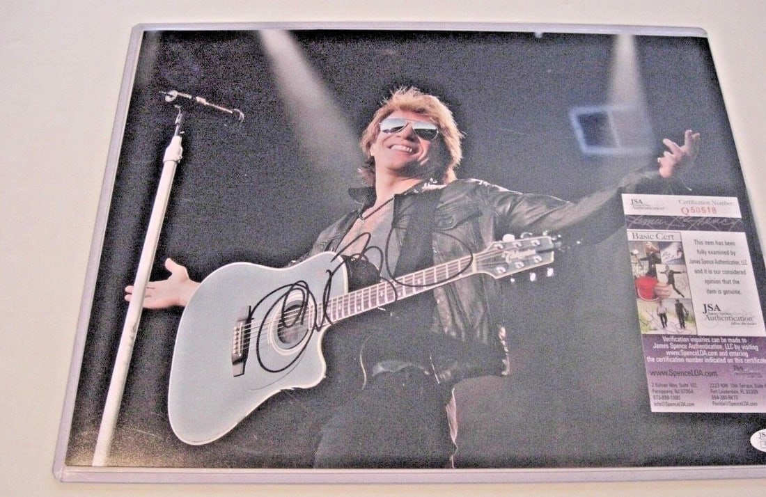 Jon Bon Jovi signed 11x14 photograph JSA COA: Jon Bon Jovi signed 11x14 photograph JSA COA This is an original 11x14 photograph signed by Jon Bon Jovi, the renowned singer and actor. The photo captures him holding an acoustic guitar, wearing sung