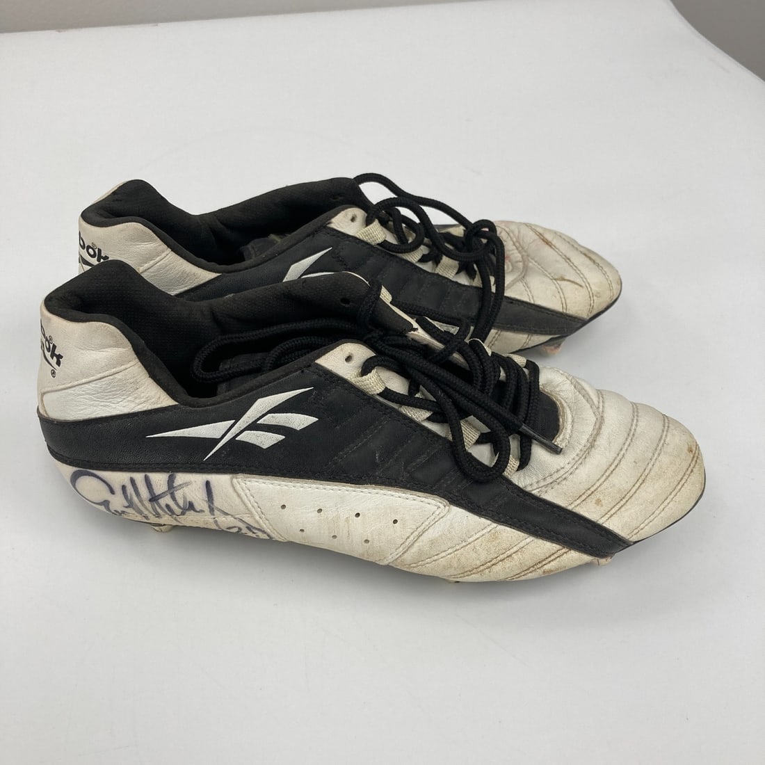 Eric Metcalf Game Used Reebok Cleats with 2 Signatures: Eric Metcalf Game Used Reebok Cleats with 2 Signatures Own a piece of football history with these game-used football cleats signed by Eric Metcalf. These Reebok shoes feature a classic white design ac