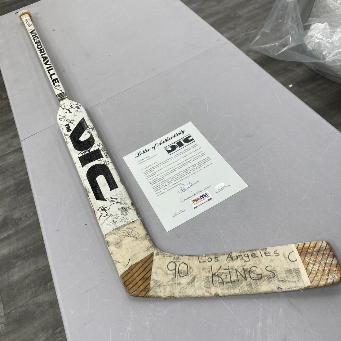 1990-91 LA Kings Signed Goalie Stick Wayne Gretzky PSA Authenticated: 1990-91 LA Kings Signed Goalie Stick Wayne Gretzky PSA Authenticated This 1990-91 Los Angeles Kings team-signed game-used goalie stick, featuring the legendary Wayne Gretzky, is a remarkable piece of 